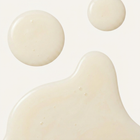 Close-up of a beige liquid with spherical droplets on a light background